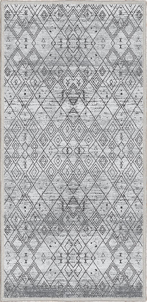 Alfombra 'Anissa' sobre fondo blanco, con diseño geométrico en tonos grises y negros, destacando patrones de rombos y detalles intrincados. El acabado sutilmente desgastado añade un toque vintage, y la alfombra es lavable en lavadora y tiene una base antideslizante.