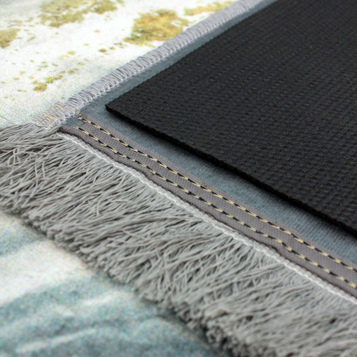 alfombra de dos capas: la capa superior es blanca y moderna, lavable en lavadora y la capa inferior es antideslizante. Ambas capas están visibles en la imagen