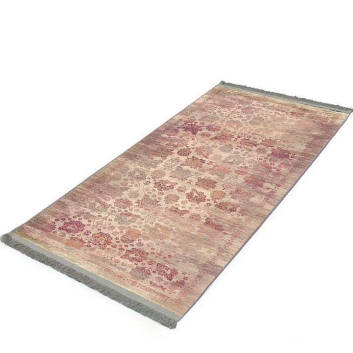 Alfombra vintage 'Rose' sobre un fondo blanco, destacando su elegante diseño con motivos florales y geométricos en tonos crema, rosas suaves y rojos intensos. Aporta sofisticación y carácter a cualquier espacio, y es lavable en lavadora.