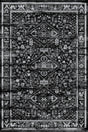 Alfombra 'Lustre' sobre un fondo blanco, resaltando su diseño simétrico con un medallón central y motivos geométricos en blanco, negro y gris, que aporta un toque de encanto vintage a cualquier espacio.