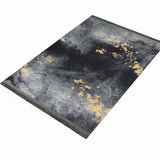 Alfombra 'Prestige' sobre un fondo blanco, destacando su diseño abstracto en tonos grises con toques dorados que simulan un cielo estrellado. Añade un toque de lujo y elegancia a cualquier espacio, y es lavable en lavadora para mayor comodidad.