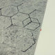 Video de la alfombra 'Terra', mostrando su diseño hexagonal en tonos grises y cómo su patrón geométrico y sofisticado aporta elegancia moderna a diferentes espacios.