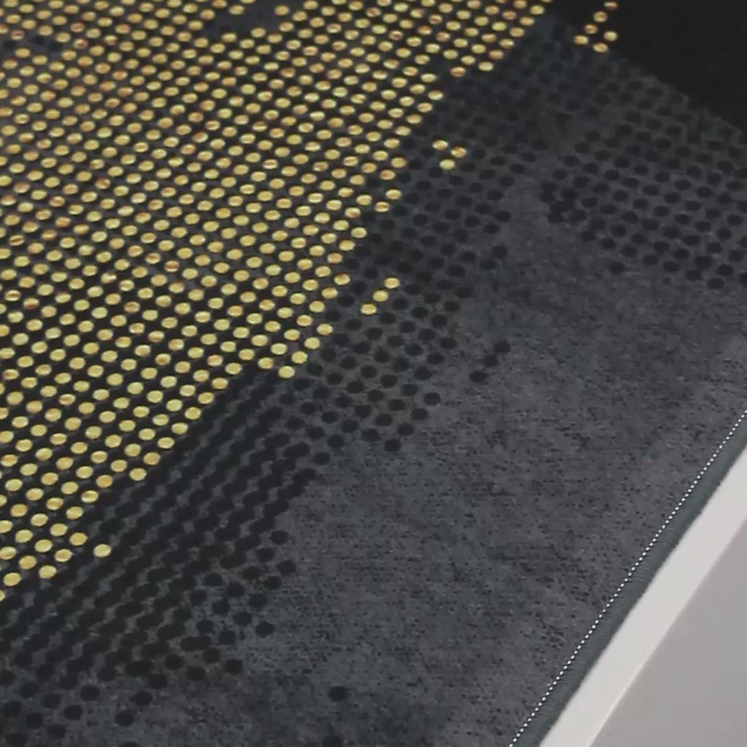 Video de la alfombra 'Mundo', mostrando su patrón dorado que evoca mapas del mundo sobre un elegante fondo gris. Esta pieza combina lujo y modernidad, añadiendo un toque cosmopolita a cualquier habitación. Además, es lavable en lavadora, ofreciendo facilidad de mantenimiento.