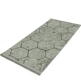 Alfombra 'Terra' sobre un fondo blanco, destacando su diseño hexagonal en tonos grises, ideal para añadir un toque de elegancia moderna y contemporánea a cualquier decoración.