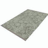 Alfombra 'Terra' sobre un fondo blanco, destacando su diseño hexagonal en tonos grises, ideal para añadir un toque de elegancia moderna y contemporánea a cualquier decoración.